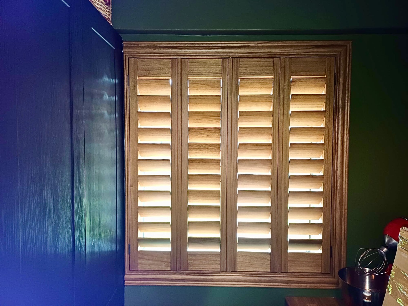 Shires Shutters installation, real oak shutter green wall